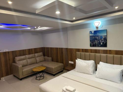 a room with a bed and a couch in it at Hotel Avenue Suites Near International Airport Bangalore in Bengaluru