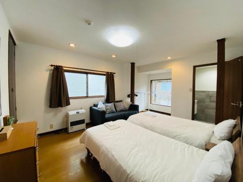 a hotel room with two beds and a couch at Bond Chalet Hakuba - Vacation STAY 76698v in Hakuba
