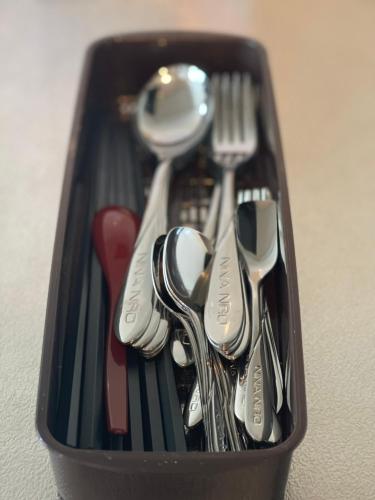 a black container filled with forks knives and spoons at Cocostay The Peace Memorial Park ココステイ平和記念公園 Excellent location overlooking Peace Park! in Hiroshima