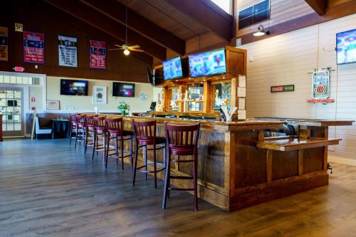 a bar with a row of bar stools in a restaurant at Hotel Cape Cod in Falmouth