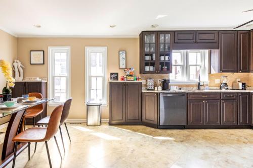 a kitchen with brown cabinets and a table and chairs at Beautiful & Large Townhouse in Downtown Arlington Near DC in Arlington