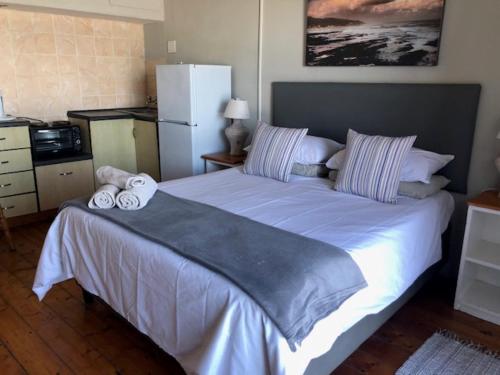 een slaapkamer met een groot bed en 2 handdoeken bij 14@Mitford in Morganʼs Bay