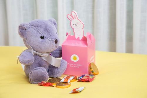a purple teddy bear sitting next to a pink box at Marco Polo Xiamen in Xiamen