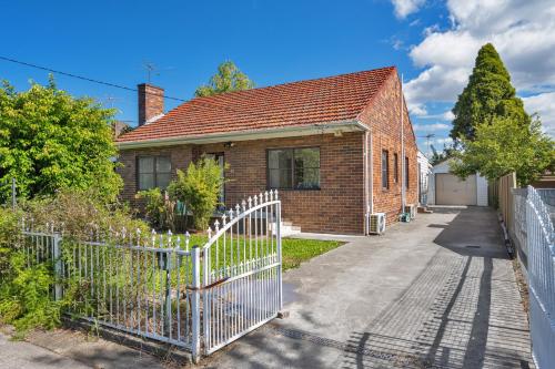 a brick house with a gate and a driveway at Belmore Brand new renovated 3Br house AC & Parking in Sydney