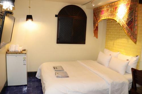 a bedroom with a white bed and a window at Hotel Marigold in Incheon