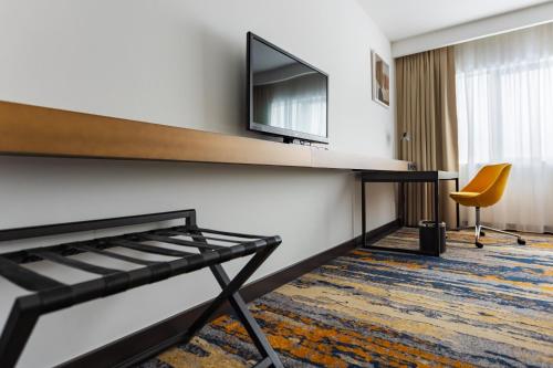 a hotel room with a desk and a tv on a wall at Crowne Plaza Belgrade by IHG in Belgrade