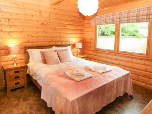 um quarto com uma cama num chalé de madeira em Cornfield Lodge em Northallerton