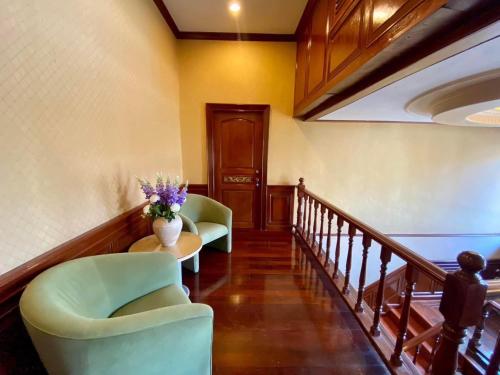a hallway with two chairs and a table with flowers on it at Angel Pool Villa Phuket - SHA Extra Plus in Phuket Town