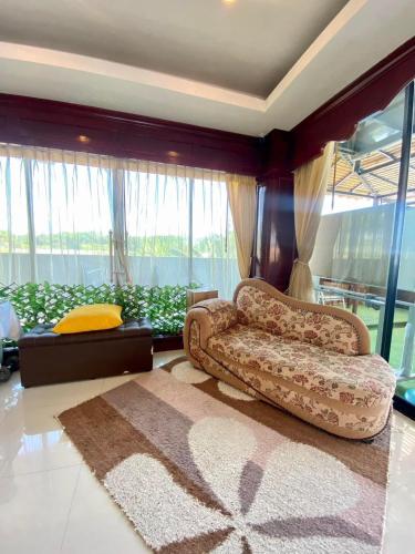 a living room with a couch and a rug at Angel Pool Villa Phuket - SHA Extra Plus in Phuket Town