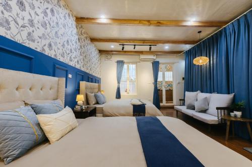a bedroom with two beds and a blue wall at Unique, private, quiet, on the most beautiful street in Hanoi in Hanoi