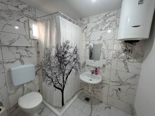 uma casa de banho branca com um WC e um lavatório em Aniva Apartments em Šušanj