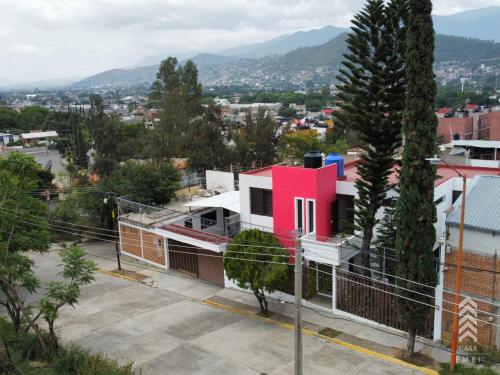 a pink house on a street in a city at Casa Embi Oaxaca in Oaxaca City