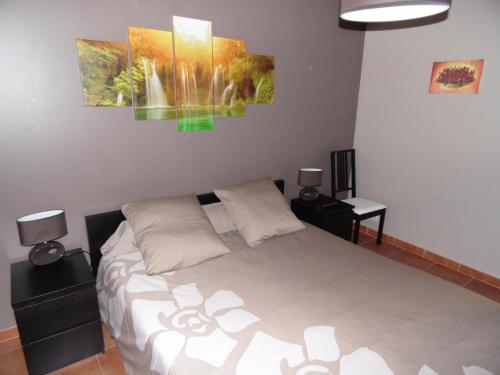 a bedroom with a bed and two paintings on the wall at Les Terrasses de Valensole in Valensole