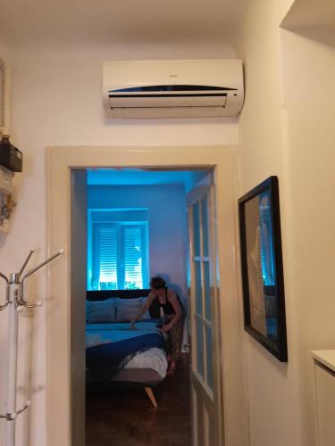 um homem está a fazer uma cama num quarto em Apartment Garson em Zagreb