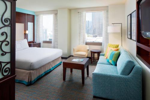pokój hotelowy z łóżkiem i niebieską kanapą w obiekcie Residence Inn by Marriott San Diego Downtown/Gaslamp Quarter w mieście San Diego