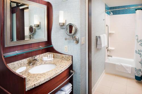 a bathroom with a sink and a mirror and a tub at Residence Inn by Marriott San Diego Downtown/Gaslamp Quarter in San Diego