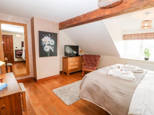 a bedroom with a bed and a television in it at The Barn in Northallerton