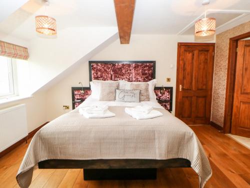 a bedroom with a large bed with two towels on it at The Barn in Northallerton