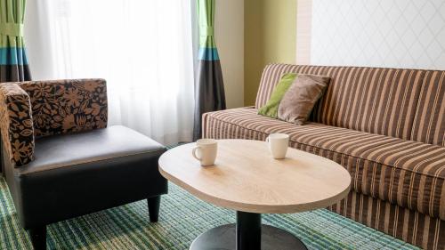 a living room with a couch and a table and a chair at New Otani Inn Sapporo in Sapporo