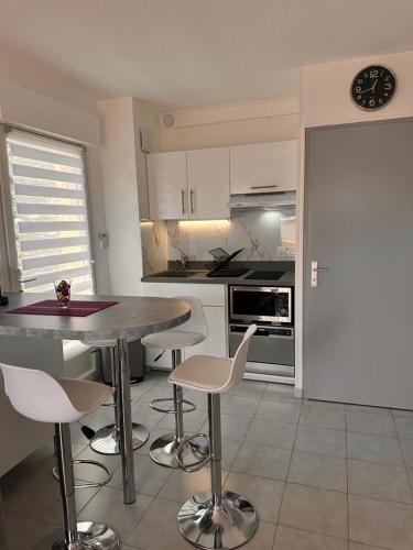 une cuisine avec une table, des chaises et une horloge dans l'établissement Le Castello, à Saint-Aygulf