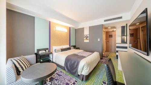 a hotel room with a bed and a table at New Otani Inn Sapporo in Sapporo