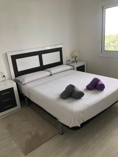Un dormitorio con una cama grande con almohadas moradas. en NUEVO. Reformado con vistas panorámicas y piscina, en Pals