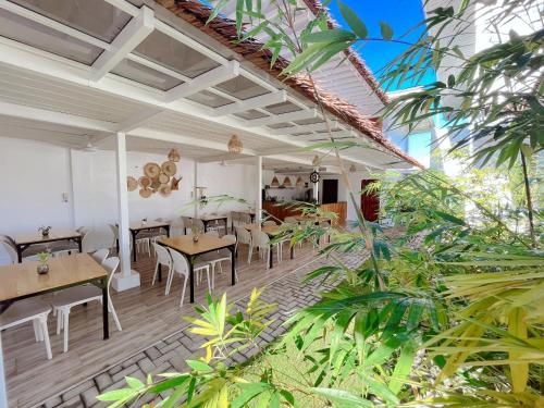 Anlio Resort في داويس: غرفة طعام بها طاولات وكراسي ونباتات
