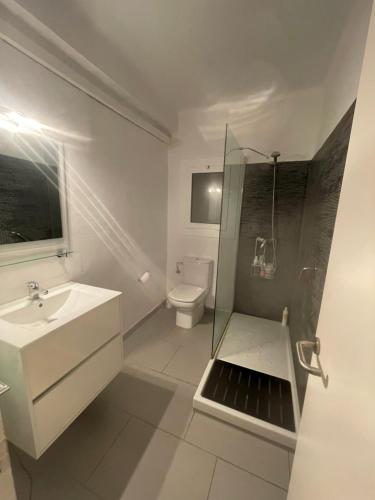 a white bathroom with a sink and a toilet at NUEVO. Reformado con vistas panorámicas y piscina in Pals