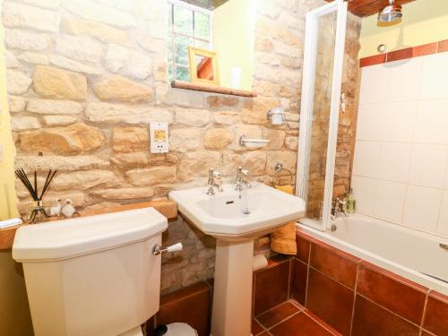 een badkamer met een toilet, een wastafel en een bad bij Hadcroft Cottage in Chipping Campden