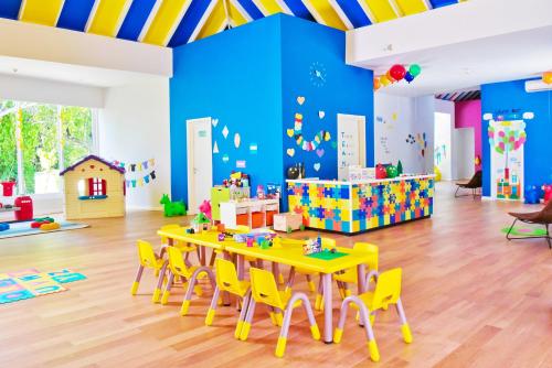 a classroom with a table and chairs in a room at Kandima Maldives in Kudahuvadhoo