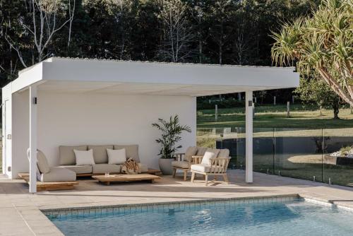 a white pergola next to a swimming pool at Amileka - luxury 25 acre estate with pool in Federal