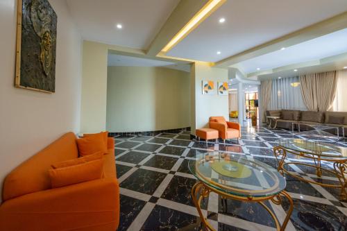 a lobby with orange chairs and a glass table at Las Vegas Garden Hotel Mbarara in Mbarara