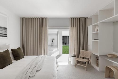 a bedroom with a large bed and a chair at Amileka - luxury 25 acre estate with pool in Federal