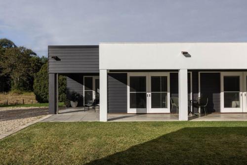 a white house with a patio and grass at Amileka - luxury 25 acre estate with pool in Federal