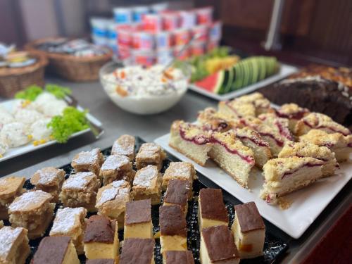 a table topped with different types of food on plates at Hotel Great Polonia Conrad Kraków in Kraków