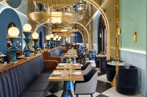 a restaurant with blue walls and tables and chairs at W Budapest in Budapest