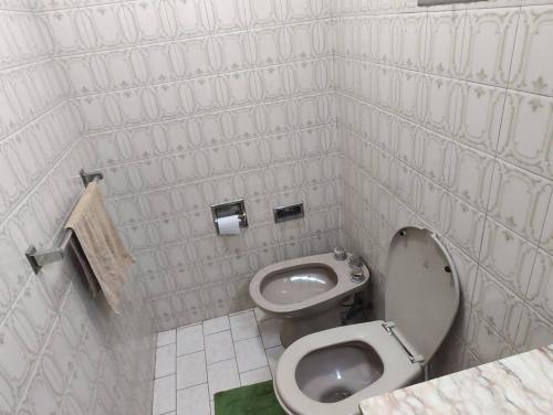 Baño blanco con aseo y lavamanos en Departamento Funcional en Guaymallén