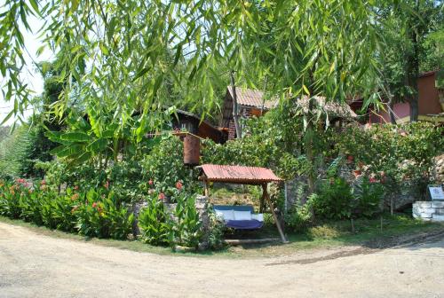 a garden with a bench and flowers in front of a house at Bungalow- casute in Orşova
