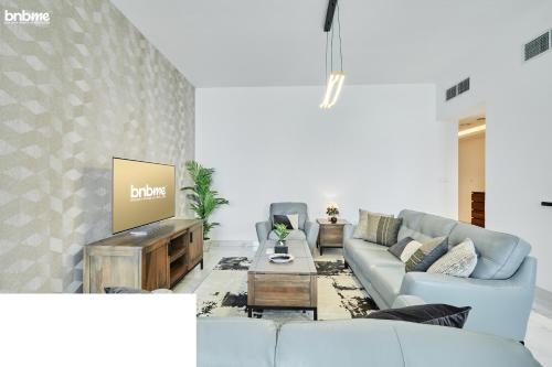 a living room with a couch and a tv at bnbmehomes - Noora Tower in Dubai