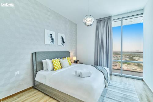 a bedroom with a bed and a large window at bnbmehomes - Noora Tower in Dubai
