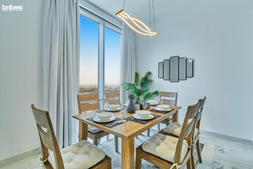 a dining room with a wooden table and chairs at bnbmehomes - Noora Tower in Dubai