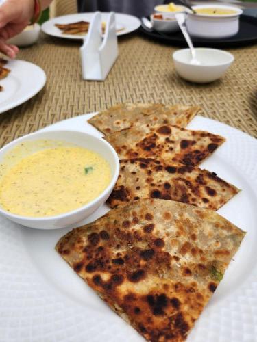 een wit bord eten met een kom soep bij Purna Boutique Resort - Luxury Villa in Bhīm Tāl