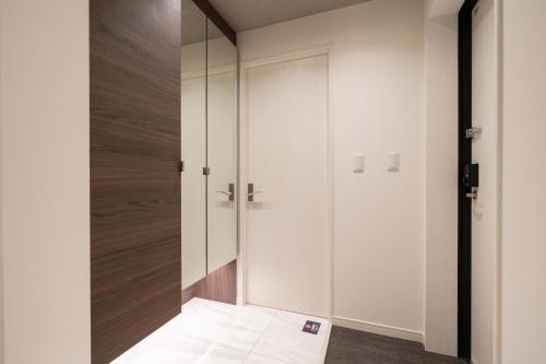 a hallway with white walls and a glass door at Bonheur Akasaka in Tokyo
