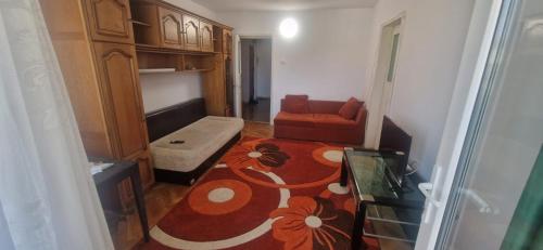- un salon avec une chaise rouge et un canapé dans l'établissement Apartament Adrian, à Eforie Nord