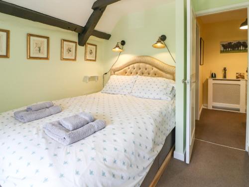 a bedroom with a large bed with two towels on it at Coln Cottage in Stow on the Wold