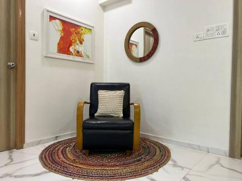 a black chair sitting in a room with a mirror at Jastcon, 19th Rd, Khar, Ambedkar Colony by Connekt Homes in Mumbai