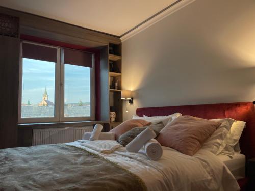 a bedroom with a large bed with a large window at Jeny Boutique Apartment in Târgu-Mureş