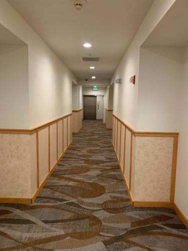 an empty hallway in a hospital with a carpeted floor at Rocklin Park Hotel, Trademark Collection by Wyndham in Rocklin
