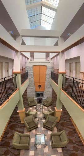 a large lobby with chairs and a skylight at Rocklin Park Hotel, Trademark Collection by Wyndham in Rocklin