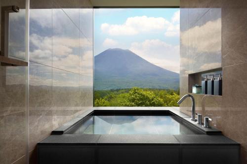 a bathroom with a bath tub with a view of a mountain at Higashiyama Niseko Village, a Ritz-Carlton Reserve in Niseko